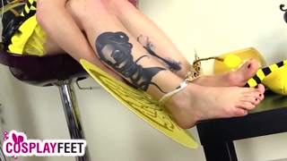 Cosplayer lility is wearing a yellow and black bee costume, with yellow high heels and striped socks