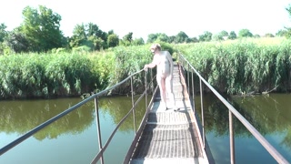 Messalina Dressed in Sun. Outside Outdoor. Nude Milf walks by bridge River. Naturist Nudist Woman