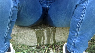 Pissing jeans in public street in sunny day